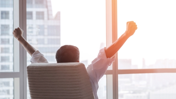 workplace mental health photo of man stretching arms in his chair to take a mental health break at work