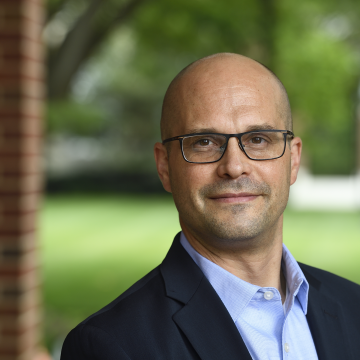 Peter DeCarlo man wearing glasses, shirt and suit jacket, standing outdoors